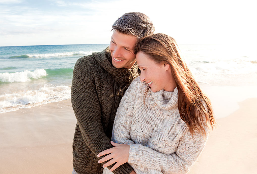 Couple serein au bord de la mer s'étant constitué une épargne complémentaire